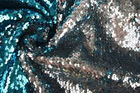 Sequin fabric is a type of textile embellished with small, shiny discs, known as sequins, which are often made from plastic or metal.